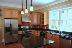 Beautiful remodeled kitchen with black island and wood cabinetry