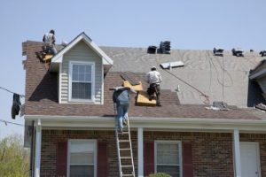 Three workers on a roof that's partially removed